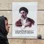 Eine iranische Frau mit Kopftuch spaziert an einem Bild vorbei, das den neuen obersten Führer Mojtaba Khamenei zeigt.