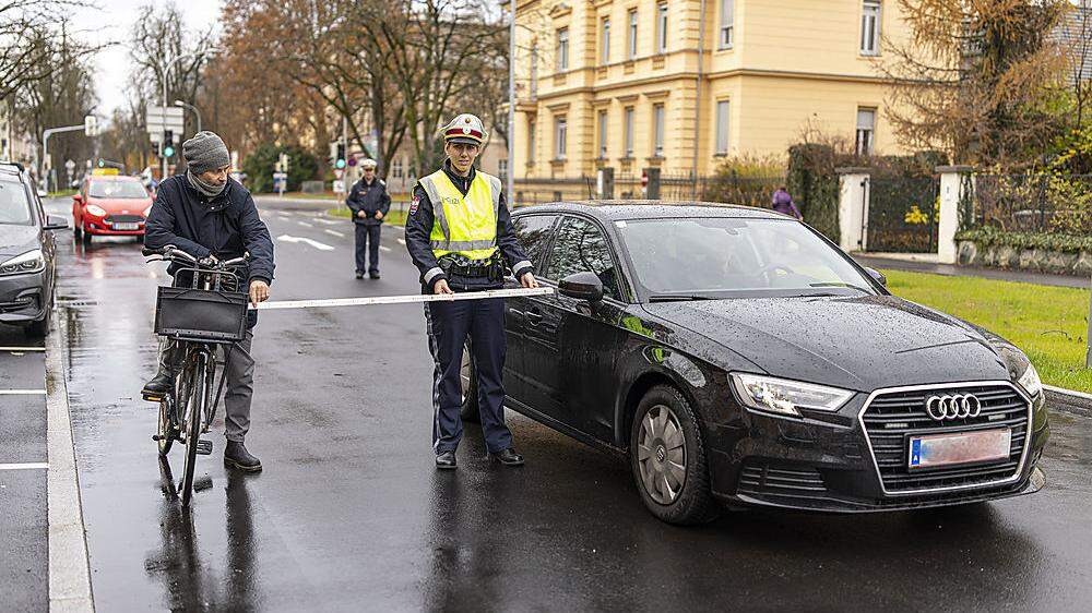 Die Polizei zeigt es in der Jessernigstraße in Klagenfurt vor: 1,5 Meter Abstand müssen beim Überholen eines Radfahrers im Ortsgebiet eingehalten werden 