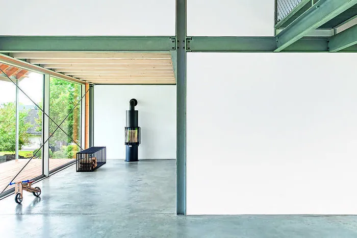 Auf zwei Geschoßen mit 195 Quadratmetern Wohnfläche reihen sich die Räume längs aneinander. Durch die großen Glasflächen verschmilzt das Haus optisch mit der Landschaft.