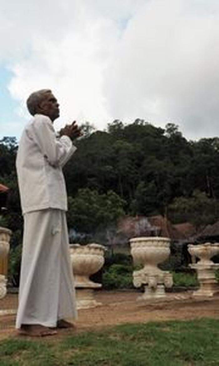 Vor dem Zahntempel in Kandy entzünden die meist weiß gekleideten Pilger Räucherstäbchen