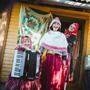 Die Frauen von Kihnu ziehen Touristen an, wie auch die Asiatin in der Mitte des Bildes in traditioneller Kihnu-Tracht  