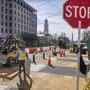 With the White House and Washington Monument in the background, a worker holds a traffic stop sign as demolition begins on the Black Lives Matter mural, Monday, March 10, 2025, in Washington. (AP Photo/Jacquelyn Martin)