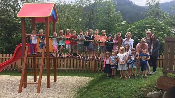 Die Kinder und ihre Betreuerinnen auf dem neu gestalteten Spielplatz, dem „Geburtstagsgeschenk“ der Gemeinde