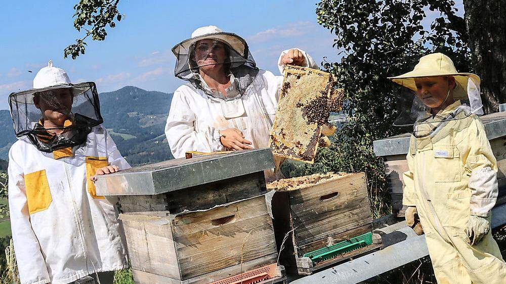 Marica Skubel mit zwei ihrer Kinder bei ihren Bienenstöcken