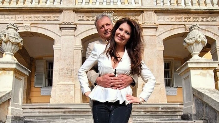 Allessa und ihr Mann Sven stehen eng umschlungen auf den Treppen vor einem Schloss – sie feierten heimlich Hochzeit
