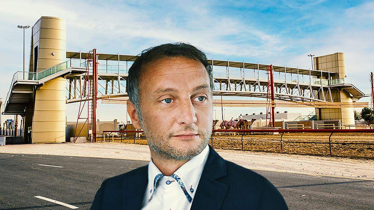 Karl Brandstätter mit einer Brücke im Hintergrund, die auch das &quot;Dach&quot; des Startbereiches für ein Kamelrennen in Dubai bildete 