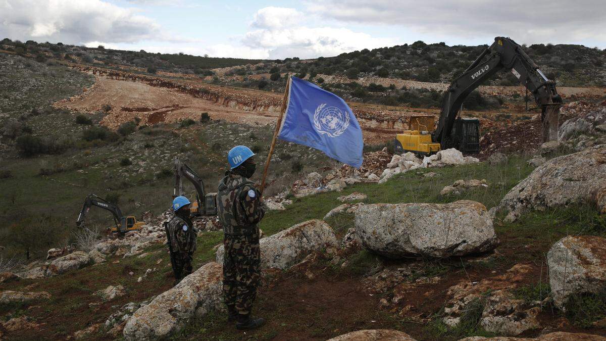 Blauhelme mit UN-Flagge zu Fuß in steinigem Gelände. | UNIFIL überwacht seit 1978 das Grenzgebiet zwischen Israel und dem Libanon. Der Blauhelmeinsatz gilt als eine der ältesten aktiven UNO-Beobachtermissionen. Gegenwärtig sind etwas mehr als 10.000 Soldaten an dem Einsatz beteiligt, darunter 175 Bundesheersoldaten.