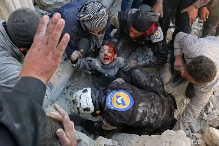 Sie sind dort, wo niemand hingeht: Syriens Weißhelme retten einen Buben aus einem zerstörten Haus.