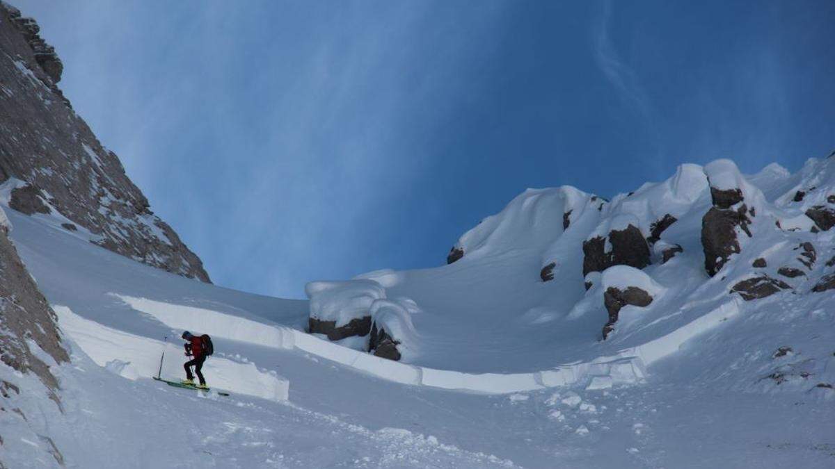 Ein Alpinpolizist befindet sich unterhalb des Laserztörls im kammnahen extrem steilen Gelände