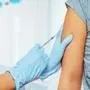 Doctor makes vaccination in the shoulder of patient in a hospital