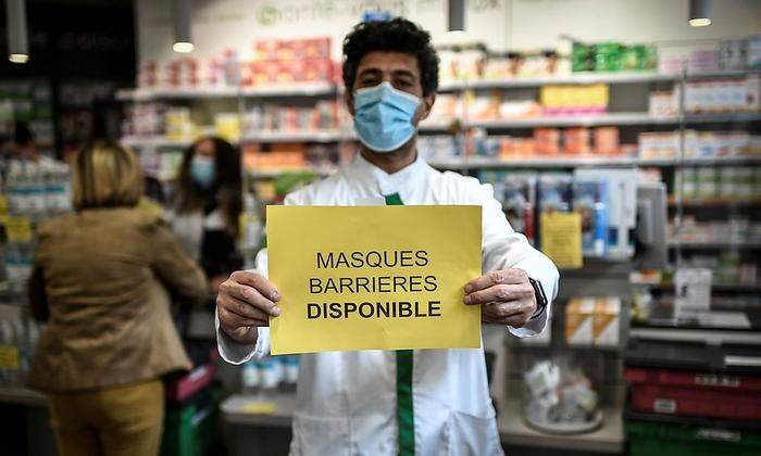 Ein franzözisischer Apotheker bringt ein Schild an, das signalisiert, dass bei ihm Masken erhältlich sind. Die Lockerungsmaßnahmen, die mit der Maskenpflicht einhergehen, treten ab dem 11. Mai ein.