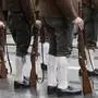 Männer in Lederhosen mit weißen Strümpfen und Haferlschuhe, die jeweils auf der rechten Seite ein Gewehr haben