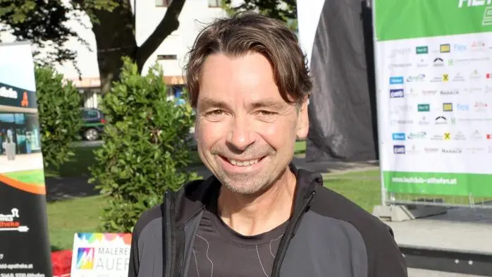 Ein Mann mittleren Alters lächelt in die Kamera. Er ist sportlich bekleidet. | Christian Müller aus Althofen ist Profi-Marathonläufer