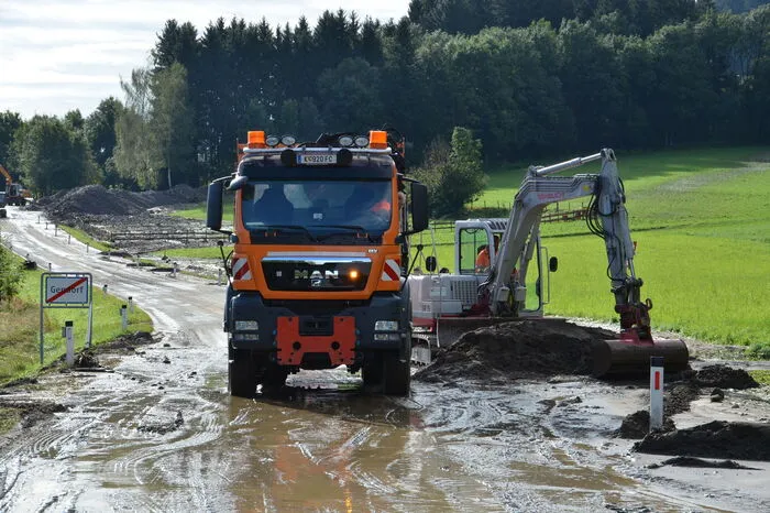 Viele LKW-Ladungen an Erde und Steinen werden abtransportiert, um die Straße wieder befahrbar zu machen.
