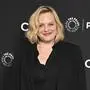 Das Bild zeigt Elisabeth Moss mit schulterlangem, welligem, blondem Haar, die auf einem schwarzen Hintergrund mit Logos von „PaleyFest“ und „Citi“ posiert. Sie trägt ein schwarzes Outfit und lächelt freundlich in die Kamera.  | Elisabeth Moss ist Mama geworden