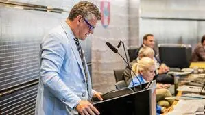 Ein Mann mit blauem Sakko und Brille steht am Rednerpult