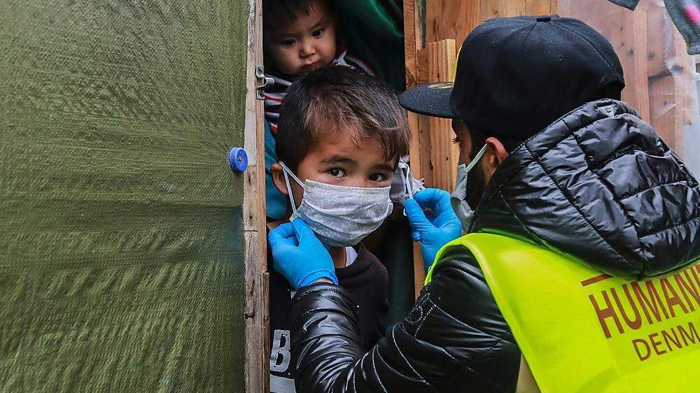 Schutzmasken werden im Lager auf der Insel Lesbos verteilt
