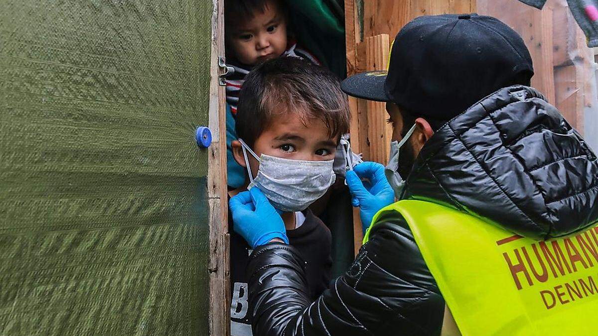Schutzmasken werden im Lager auf der Insel Lesbos verteilt