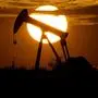 FILE - In this April 8, 2020 file photo, the sun sets behind an idle pump jack near Karnes City, USA. The 23-member OPEC+ group, led by member Saudi Arabia and non-member Russia, meets online to decide production levels from February. Analysts say the group is likely to add 400,000 barrels per day, sticking with the road map they have followed since August to add back that much oil each month.  (AP Photo/Eric Gay, File)
