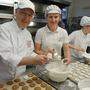 Echte Handarbeit: Michael Regner hilft mit, die Lebkuchen mit Zuckerguss zu überziehen