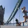 A runner passes over Tower Bridge, in central London, on the course of the London Marathon, which was postponed to help curb the spread of the coronavirus, Sunday April 26, 2020. (Dominic Lipinski/PA via AP)