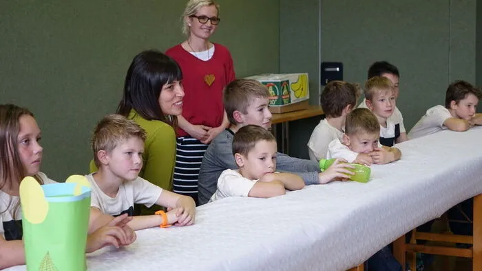 Ein Teil des langen Podiums voller Schüler in Neudorf mit Leiterin Carina Sumper (li.) und Lehrerin Martina Essl