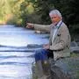 Ulrich Habsburg-Lothringen sitzt auf einem Stein und zeigt auf einen Fluss. | Ulrich Habsburg-Lothringen bei seinen Fischereigründen