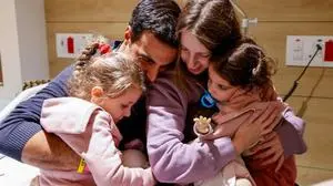 TOPSHOT - An image distributed by the Schneider Children Medical Centre shows Yoni Asher being reunited with his children Aviv, 2.5 years old, her sister Raz, 4.5 years old, and his wife Doron, on November 25, a day after they were released by Hamas in a hostage-prisoner exchange deal. After 48 days of gunfire and bombardment that claimed thousands of lives, a four-day truce in the Israel-Hamas war began on November 24 with 50 hostages set to be released in exchange for 150 Palestinian prisoners. (Photo by Schneider Hospital Spokesperson's Office / AFP) / RESTRICTED TO EDITORIAL USE - MANDATORY CREDIT "AFP PHOTO / Shneider Hospital Spokesperson's Office" - NO MARKETING NO ADVERTISING CAMPAIGNS - DISTRIBUTED AS A SERVICE TO CLIENTS