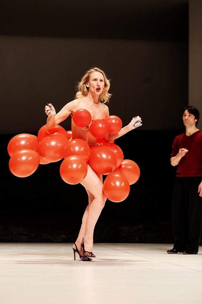 Witzig: eine nur mit roten Luftballons bekleidete Frau erzählt aus ihrer Schulzei