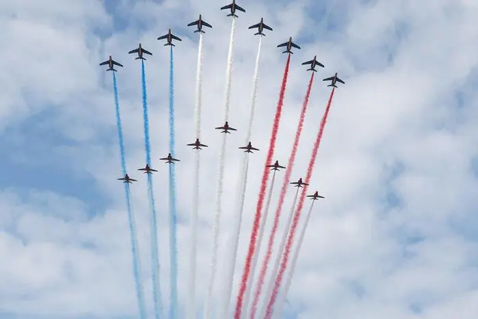 The French Air Force elite acrobatic flying team "Patrouille de France" (Top) followed by the British Royal Air Force's (RAF) aerobatic team, the "Red Arrows" perform a flypast above during the International commemorative ceremony at Omaha Beach marking the 80th anniversary of the World War II "D-Day" Allied landings in Normandy, in Saint-Laurent-sur-Mer, in northwestern France, on June 6, 2024. The D-Day ceremonies on June 6 this year mark the 80th anniversary since the launch of 'Operation Overlord', a vast military operation by Allied forces in Normandy, which turned the tide of World War II, eventually leading to the liberation of occupied France and the end of the war against Nazi Germany. (Photo by Ludovic MARIN / AFP)