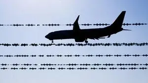 ABD0002_20250811 - LANGENHAGEN - DEUTSCHLAND: ++ ARCHIVBILD ++ ARCHIV - 17.02.2025, Niedersachsen, Langenhagen: Ein Flugzeug fliegt hinter Stacheldraht am Flughafen Hannover. (zu dpa: «Mehr als jeder zehnte Abgeschobene ist minderjährig») Foto: Julian Stratenschulte/dpa +++ dpa-Bildfunk +++. (ARCHIVBILD VOM 17.2.2025) - FOTO: APA/dpa/Julian Stratenschulte