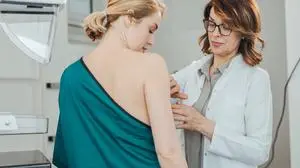 Woman gynecologist doing breast exam to her patient.
