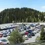 Voller Parkplatz, im Hintergrund Bergpanorama