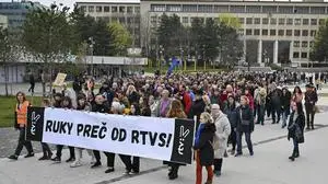People hold a banner reading "Hands off rtvs (Slovakian public radio and tv) " as they take part in a protest organised by the Slovakian opposition parties in Bratislava, Wednesday, March. 27, 2024. People in Bratislava have formed a human chain around the building of Slovakia’s public radio and television to protest a plan by the government of populist Prime Minister Robert Fico to take over the broadcasters. The plan has been condemned President Zuzana Čaputová, opposition parties, local journalists, international media organizations, the European Commission and others have warned the changes would give the government’s full control of public broadcasting. (Pavol Zachar/TASR via AP)