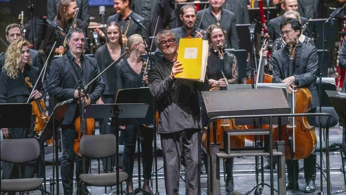 Ingo Metzmacher hält die Partitur in die Höhe