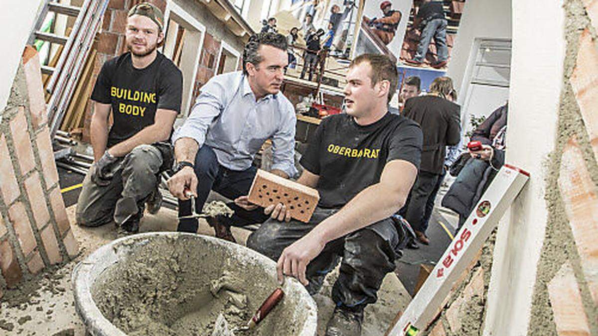 Ziegel auf Ziegel. Fürs Foto packte Darmann auf der Häuslbauermesse mit an