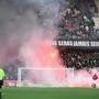 Montpellier's supporters light flares in front of stadium security staff members during the French L1 football match between Montpellier Herault SC and AS Saint-Etienne at Stade de la Mosson in Montpellier, southern France, on March 16, 2025. (Photo by Sylvain THOMAS / AFP)