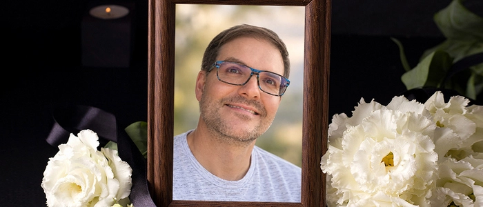 Ein gerahmtes Foto eines lächelnden Mannes mit Brille.