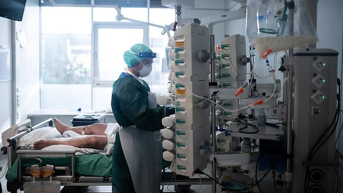 ABD0090_20201028 - ESSEN - DEUTSCHLAND: dpatopbilder - 28.10.2020, Nordrhein-Westfalen, Essen: Eine Mitarbeiterin der Pflege in Schutzausrüstung betreut einen Corona-Patienten. Menschen mit Corona-Infektion werden auf der Intensivstation IT2 im Operativen Zentrum II des Universitätsklinikum Essen behandelt. Foto: Fabian Strauch/dpa +++ dpa-Bildfunk +++. - FOTO: APA/dpa/Fabian Strauch