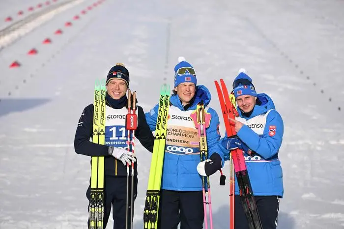 (L-R) Silver medalist Sweden’s William Poromaa, gold medalist Norway’s Johannes Hoesflot Klaebo and bronze medalist Norway’s Simen Hegstad Krueger celebrate after the men's 50km Mass Start Free event of the Cross Country discipline at the FIS Nordic World Ski Championships in Trondheim, Norway on March 8, 2025.  (Photo by Jonathan NACKSTRAND / AFP)