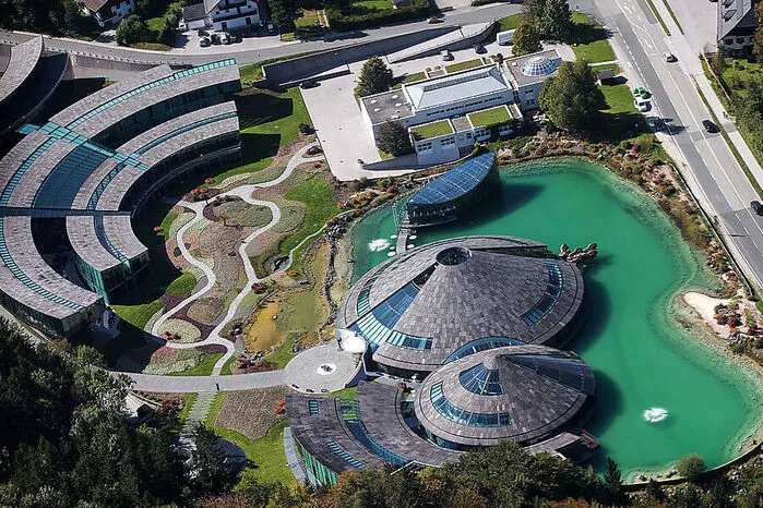 Doch man muss nicht in die Ferne schweifen, um ausgefallene Firmenzentralen zu finden. In Fuschl hat Red Bull sich ein architektonisches Denkmal gesetzt. Verantwortlich für das Design zeichnete der Osttiroler Künstler Jos Pirkner. Das Zentrum des 2014 fertiggestellten Gebäudekomplexes sind zwei nach innen offene Gebäude mit einer Skulptur einer Bullenherde, die in einen angelegten Teich zu laufen scheint.