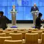 Photographers move around in a nearly empty press room as European Council President Charles Michel, right, and European Commission President Ursula von der Leyen, left, speak after a video-conference with G7 leaders at the European Council building in Brussels, Monday, March 16, 2020. European Commission President Ursula von der Leyen wants the European Union to put in place a 30-day ban on people entering the bloc for non-essential travel reasons in an effort to curb the spread of coronavirus. For most people, the new coronavirus causes only mild or moderate symptoms, such as fever and cough. For some, especially older adults and people with existing health problems, it can cause more severe illness, including pneumonia. (AP Photo/Olivier Matthys)