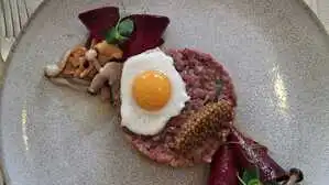 Tatar vom Hirschkalb mit Wachtelei und eingelegten Schwammerln.