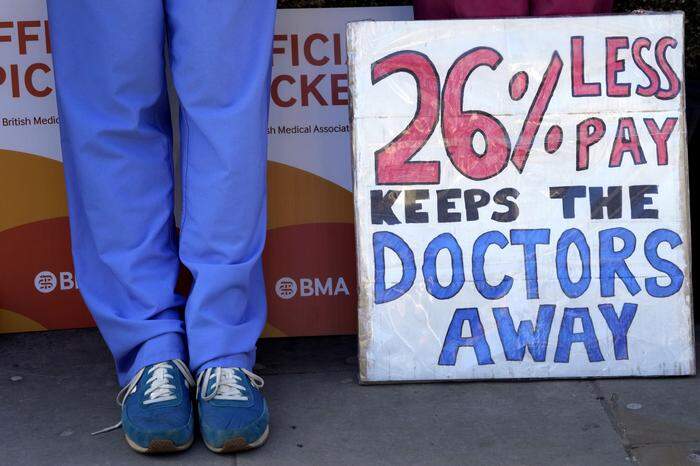 "26 % weniger Gehalt, das hält die Ärzte fern", steht auf diesem Schild, das bei einer Demo mitgebracht wurde.