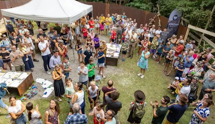 Claudia Moser spricht, umrahmt von Kindern und Eltern, bei Spielfeld Kultur