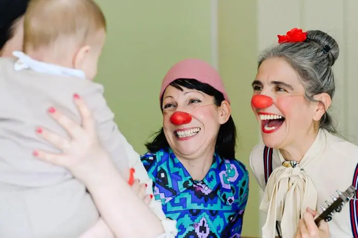 Ein Herzensmoment auf der Kinderstation: Die Clowns Rita und Mariangela gestalten eine liebevolle Spielsituation am Krankenbett und bringen Leichtigkeit in den Klinikalltag