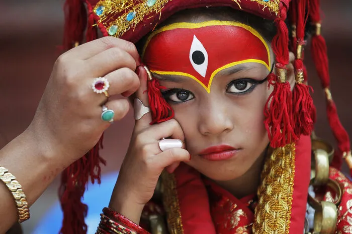 Ein Mädchen wird in Nepal von ihrer Mutter als "Kumari", eine sogenannte Kindgöttin, hergerichtet. Die Kumari gilt in Nepal seit dem 16. Jahrhundert als eine Inkarnation der furchterregenden hinduistischen Göttin Taleju, die im Nepal eine Form der Durga darstellt. Die Anfänge dieser Tradition reichen bis ins 14. Jahrhundert zurück.