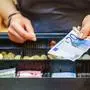 woman is paying In cash with euro banknotes
