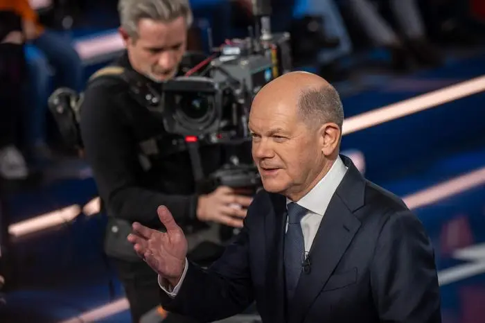 German Chancellor Olaf Scholz gestures as he talks with citizens during the TV Programm 'Klartext' hosted by the public broadcaster ZDF in Berlin on February 13, 2025. (Photo by Michael Kappeler / POOL / AFP)