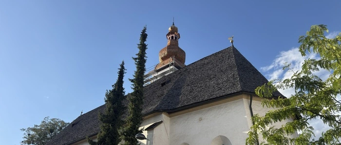Die St. Michaelskirche in Lienz mit renoviertem Turm und baufälligem Dach